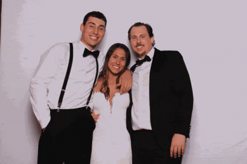 three people posing for a po together on their wedding day