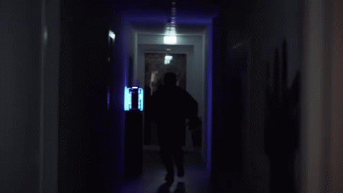 a person walking down the hallway of a house