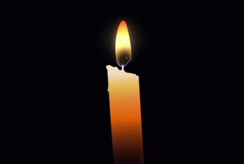 a candle sitting in the middle of a black background