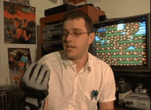 a man holding a baseball glove in front of a television