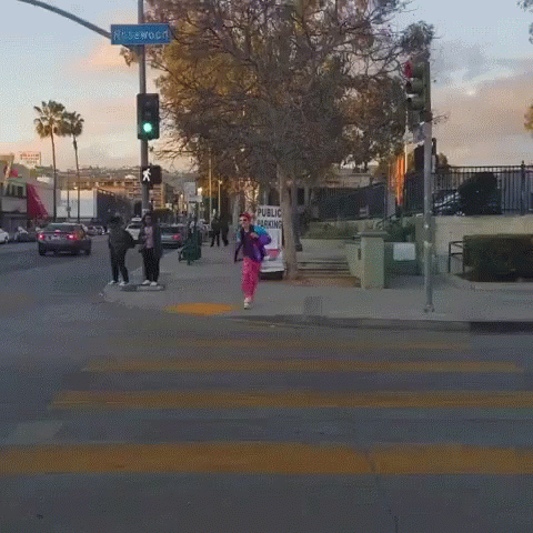 an intersection with some people crossing the street