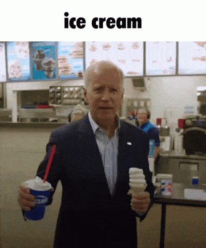 an older man stands with two cups, and has ice cream in his hands