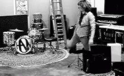 the woman is standing in front of the drum kits