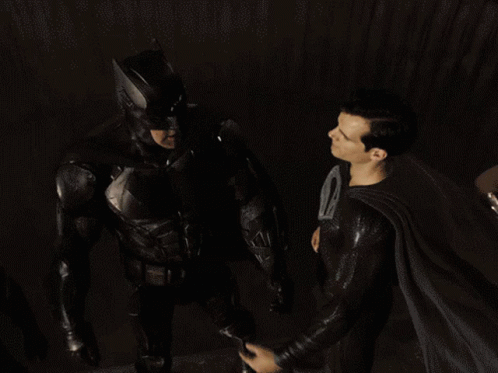 the male batman and black knight are standing in a dark room