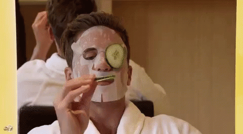 a man with a mask on brushing his teeth in front of a mirror
