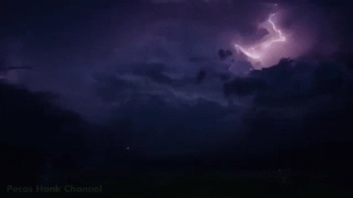 lightning strikes behind a cloudy sky as it flashes