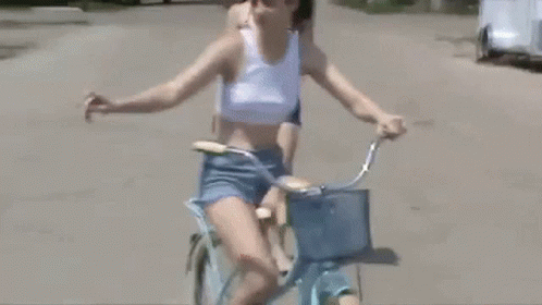 woman on bike with yellow basket on road