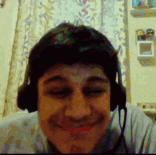 a boy with headphones is laughing and making faces