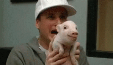 a man wearing a baseball cap holding a puppy in his hands