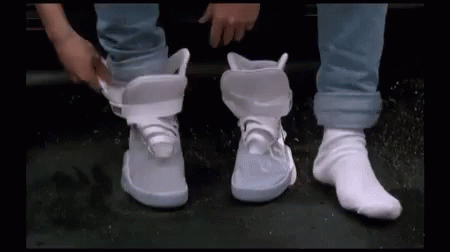 person standing up with their feet crossed wearing white sneakers