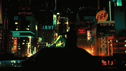 a man in a dark city with buildings lit up