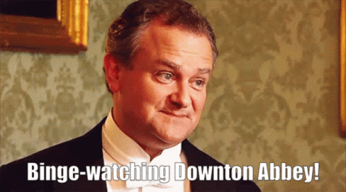 a man in a black jacket and white shirt has a blue wording that reads binge - watching downton abley