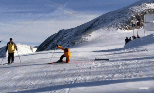 two snow skiers and one is falling off their skis