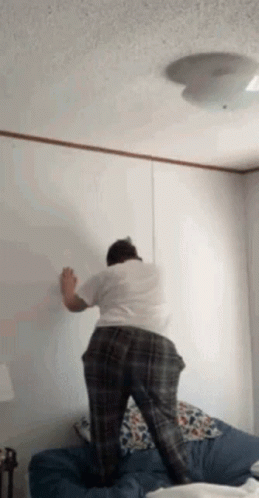 a person is painting the wall of a bedroom