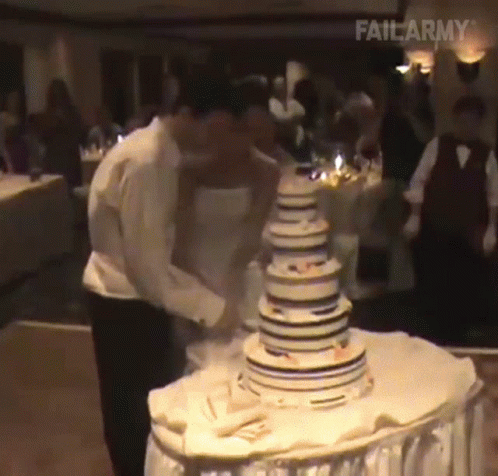 two people are  into some very large cake