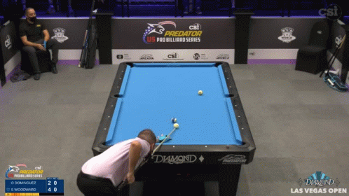 a person standing near a pool table playing with balls