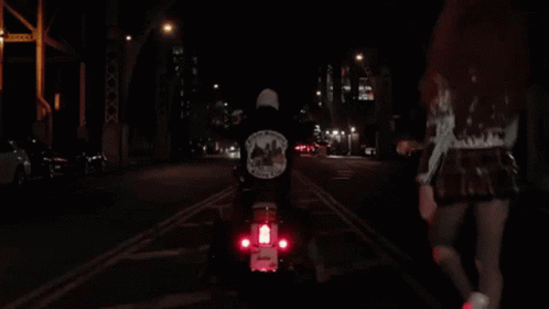 a person riding down the street on a scooter