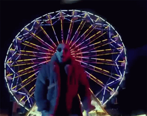 a person standing in front of a ferris wheel