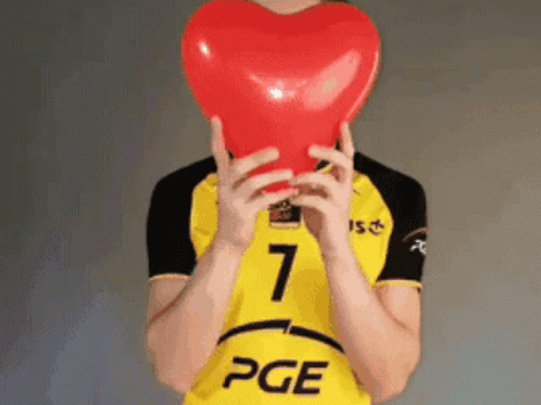 a man holding an inflatable heart up to his face