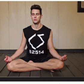 a man sitting in a yoga position with his head bowed
