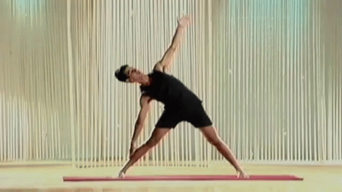 a man in black shirt and shorts doing yoga poses