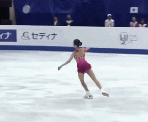 a female figure skating on ice at an ice rink