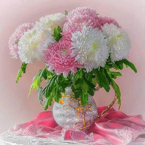 bouquet of flowers sitting on display next to white lace