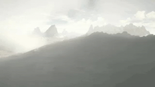 a blurry po of fog over a hill