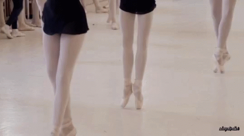 two women in short skirts and high heels walk down a white runway