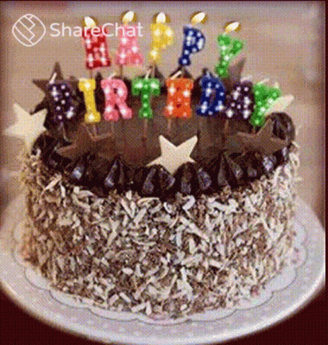 a decorated birthday cake is shown with lit candles