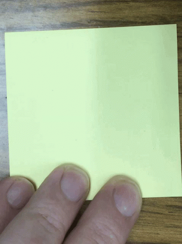 a person holding up a green piece of paper