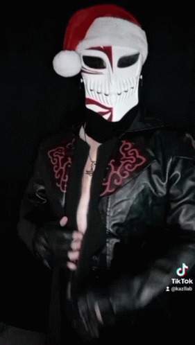 a man dressed in a black leather jacket with a face painted with white