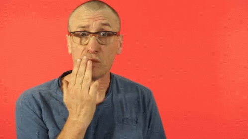 a man with glasses on holding his hand to his mouth