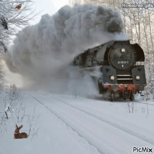 a train is blowing black dust in the snow