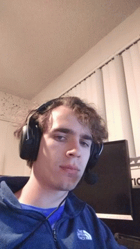 a young man wearing headphones at home on his computer