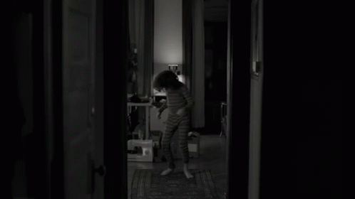 a woman standing in the doorway of her home at night