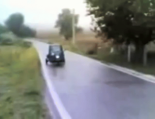 blurred po of cars driving down a road in the rain