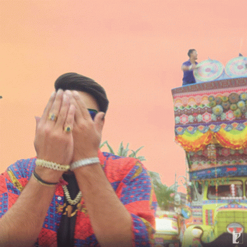 the man is covering his eyes in front of a carnival float