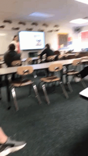 people are sitting at desks in an empty classroom