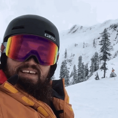 a man on skis is smiling at the camera