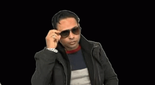 a man in black jacket and sunglasses talking on a cellphone