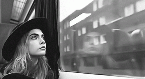 woman with large hat looking out the window