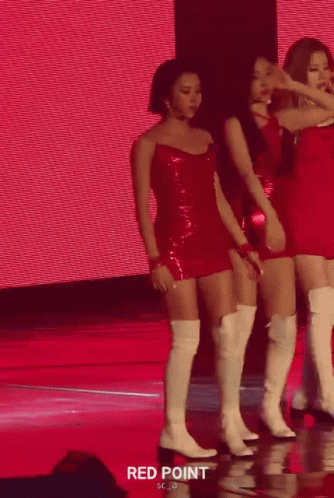 three female dancers on stage are hugging