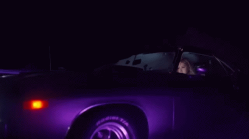 a dark picture with pink lighting and a car