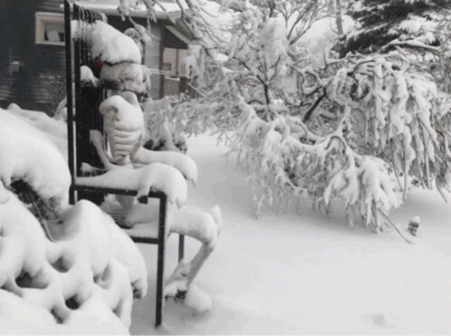 a person sits in a chair covered by snow