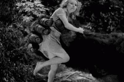 a woman standing outside in a wooded area with fire hydrant