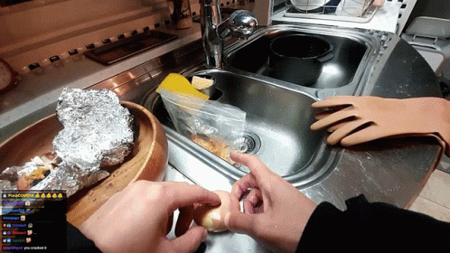 a person is washing up a large amount of food in a blue container