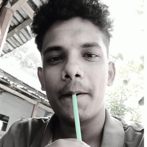 the young man with the straw is drinking from a cup