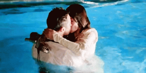 a couple hugging each other in water