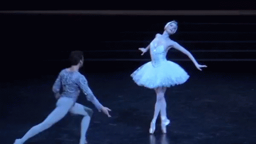 two ballerinas are in a black room